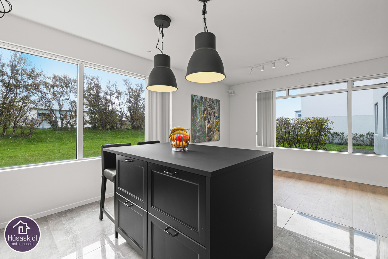 Eldhúsið er hjarta hússins með stórum gluggum og eyju.